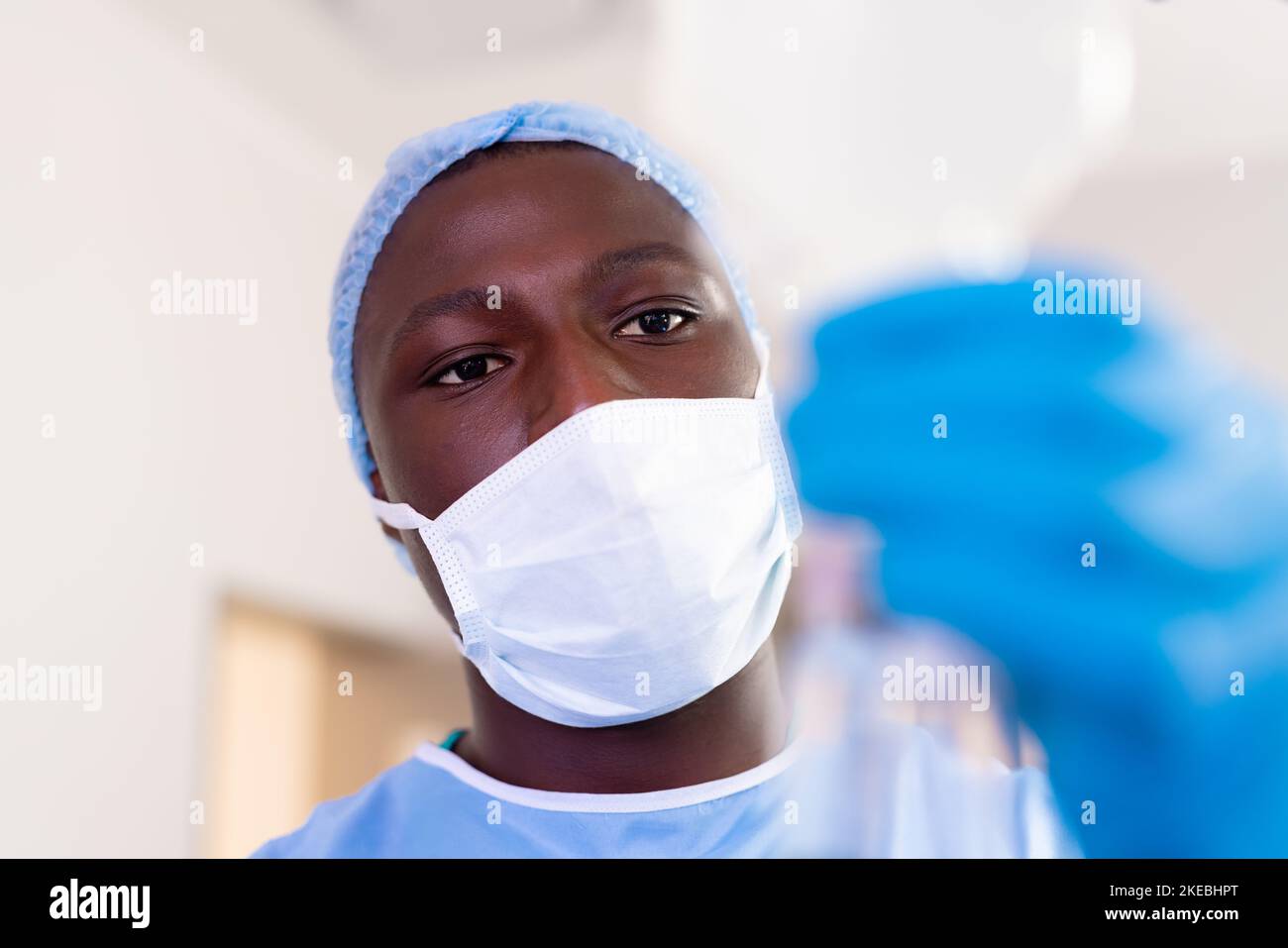 African american male surgical tech preparing iv fluid bag in operating