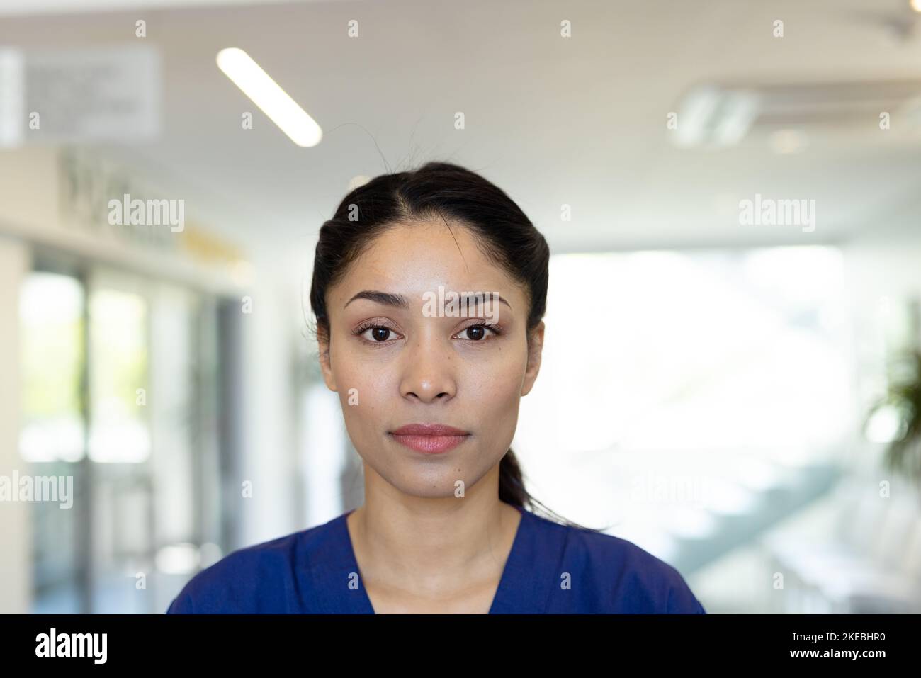 Portrait of biracial female healthcare worker in hospital corridor