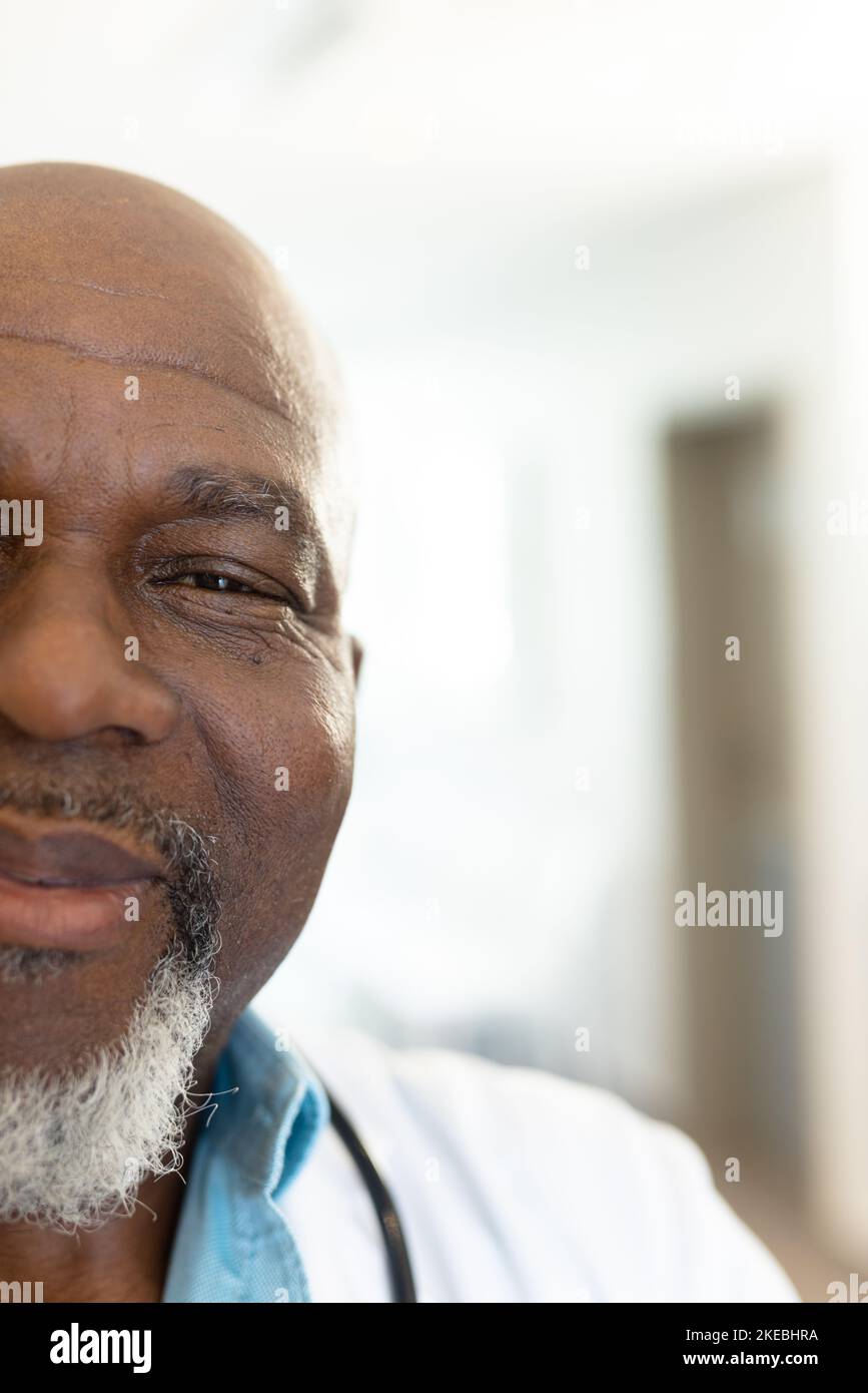 Vertical half face portrait of smiling senior african american male doctor, with copy space Stock Photo