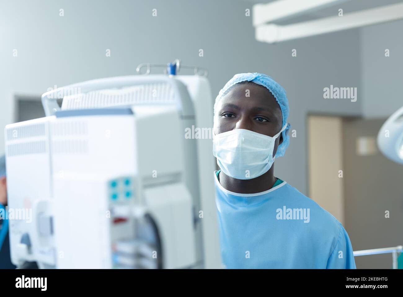 African american male surgeon in mask using computer equipment in operating theatre, with copy space Stock Photo