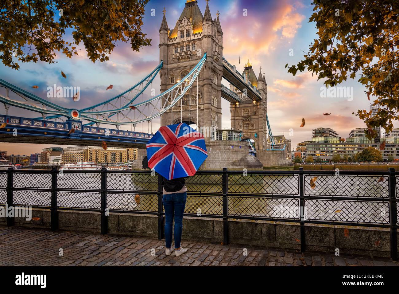 London in autumn concept with a tourist holding a british flag umbrella