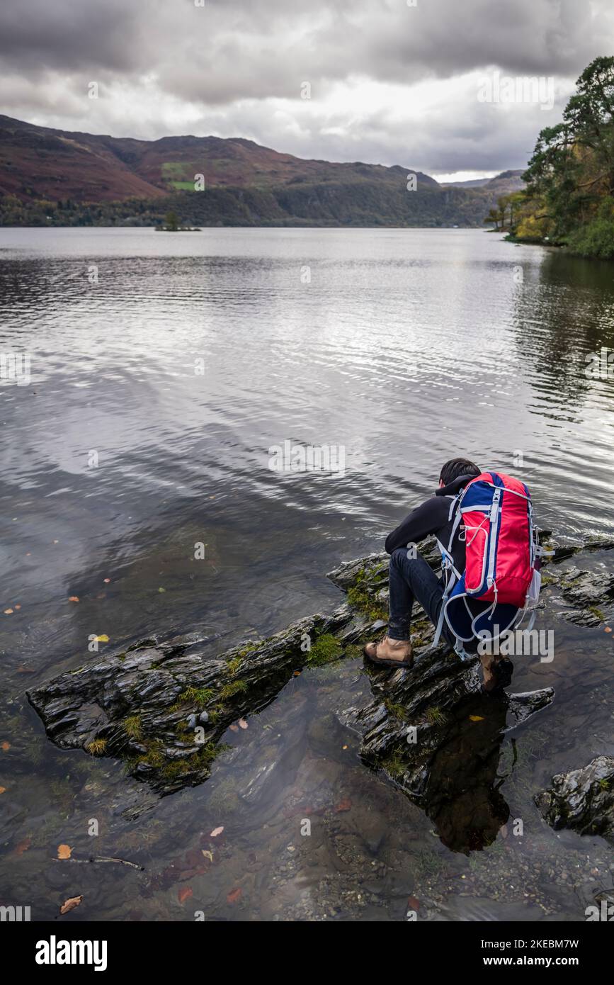 Young male hiker on the shoreline of Derwentwater, English Lake District. Stock Photo