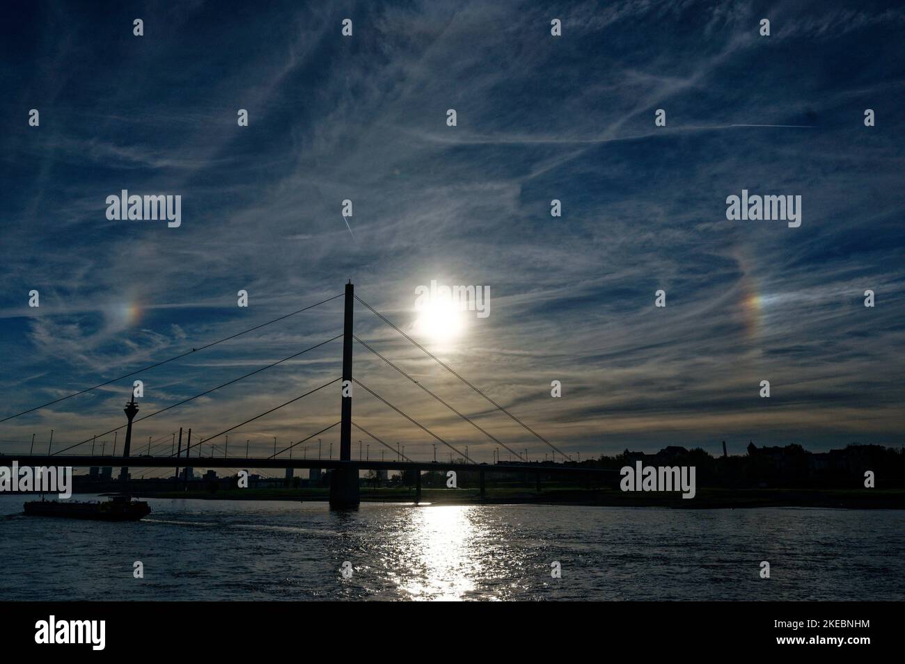 Duesseldorf, Germany. 11th Nov, 2022. Two spots of light appear in the afternoon sky at an angle of 22 degrees to the right and left of the sun. The phenomenon, called a parhelion, is caused by ice crystals in the upper atmosphere. Credit: Henning Kaiser/dpa/Alamy Live News Stock Photo