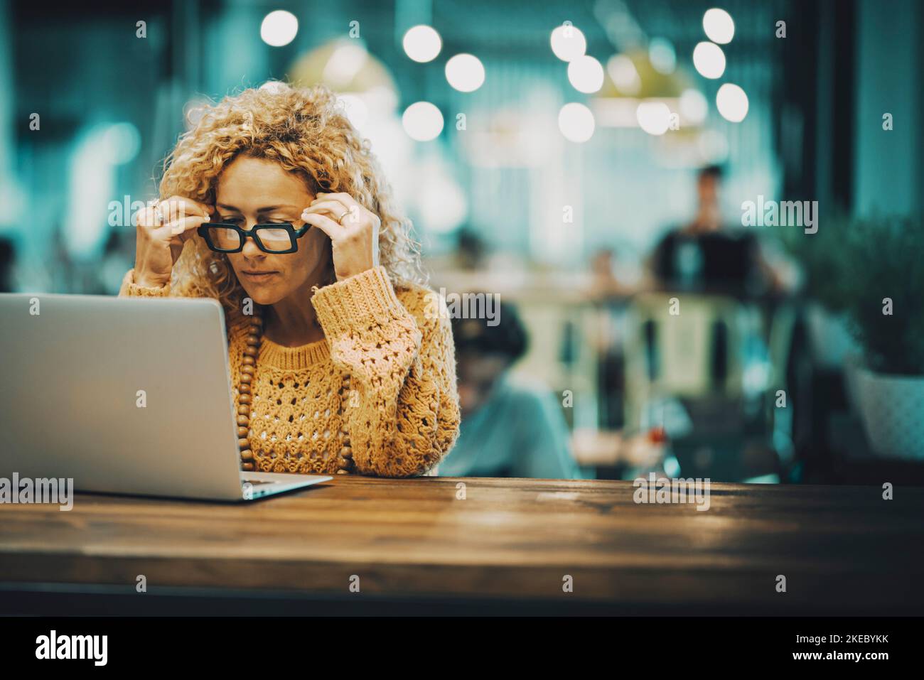 Concentrated and stressed caucasian adult woman at work on a laptop connected computer - airport gate waiting for the flight or modern office workstation - people with technology and wireless internet Stock Photo