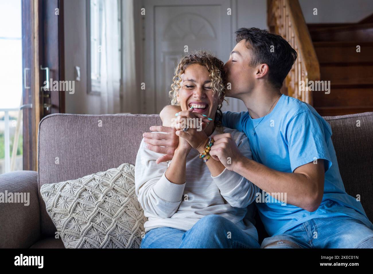 Portrait of grateful teenager man hug smiling middle-aged mother show love and care, thankful happy grown-up son in embrace cheerful mom, enjoy weekend family time at home together, bonding concept Stock Photo