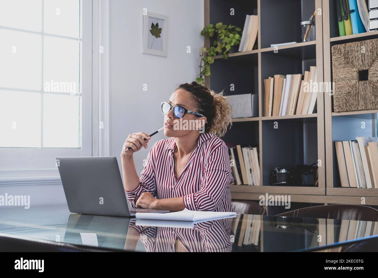 Caucasian reflexive looking at laptop screen, reflexing on work, businesswoman independent working in a difficult project. Female person preparing at home in the office indoor. Stock Photo
