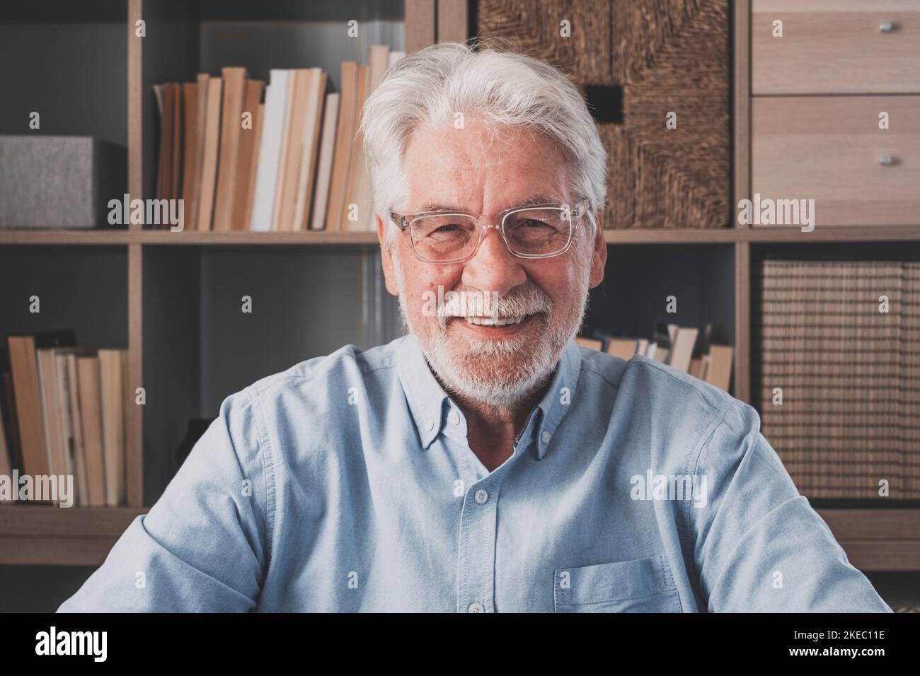 Portrait of one old cheerful male senior smiling having fun at home. Mature caucasian man studying independent looking at the camera and posing to picture. Stock Photo