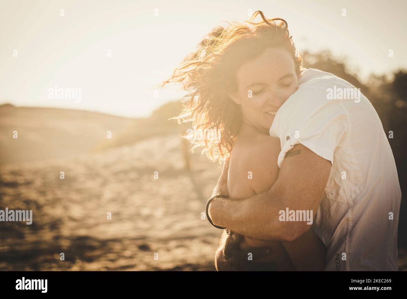 cute cuople of two adults hugged and falling in love together - woman with closed eyes hugging her boyfriend Stock Photo