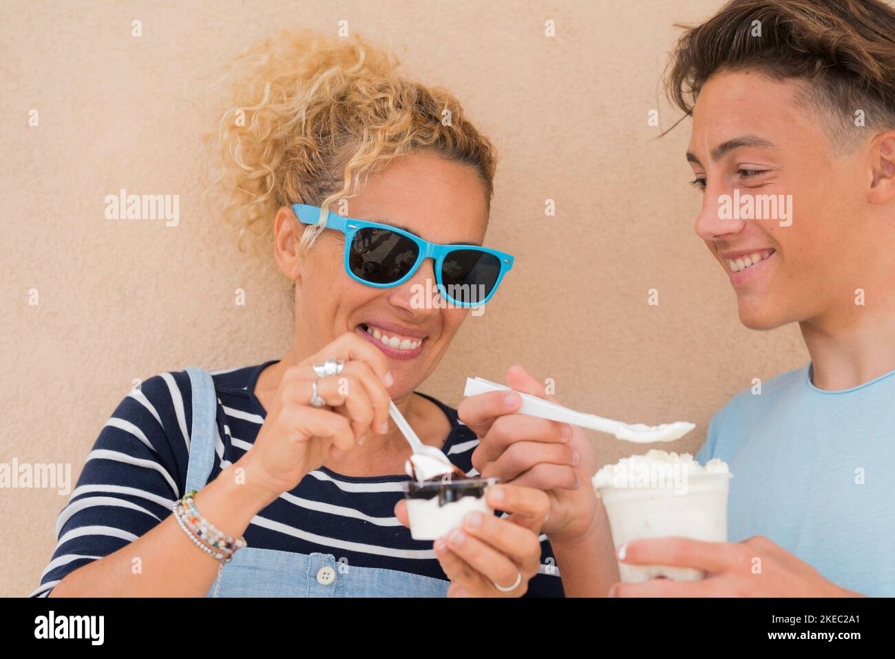 couple of two poeple they are son and mother eating milkshake and ice cream together smiling and having fun Stock Photo