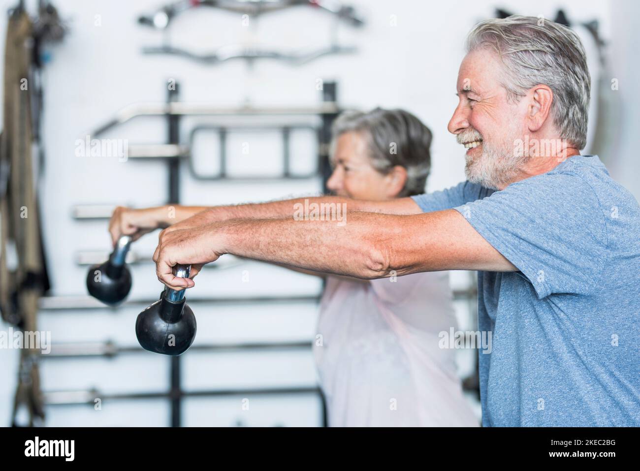 two happy and mature active senior and healthy people doing exercise at