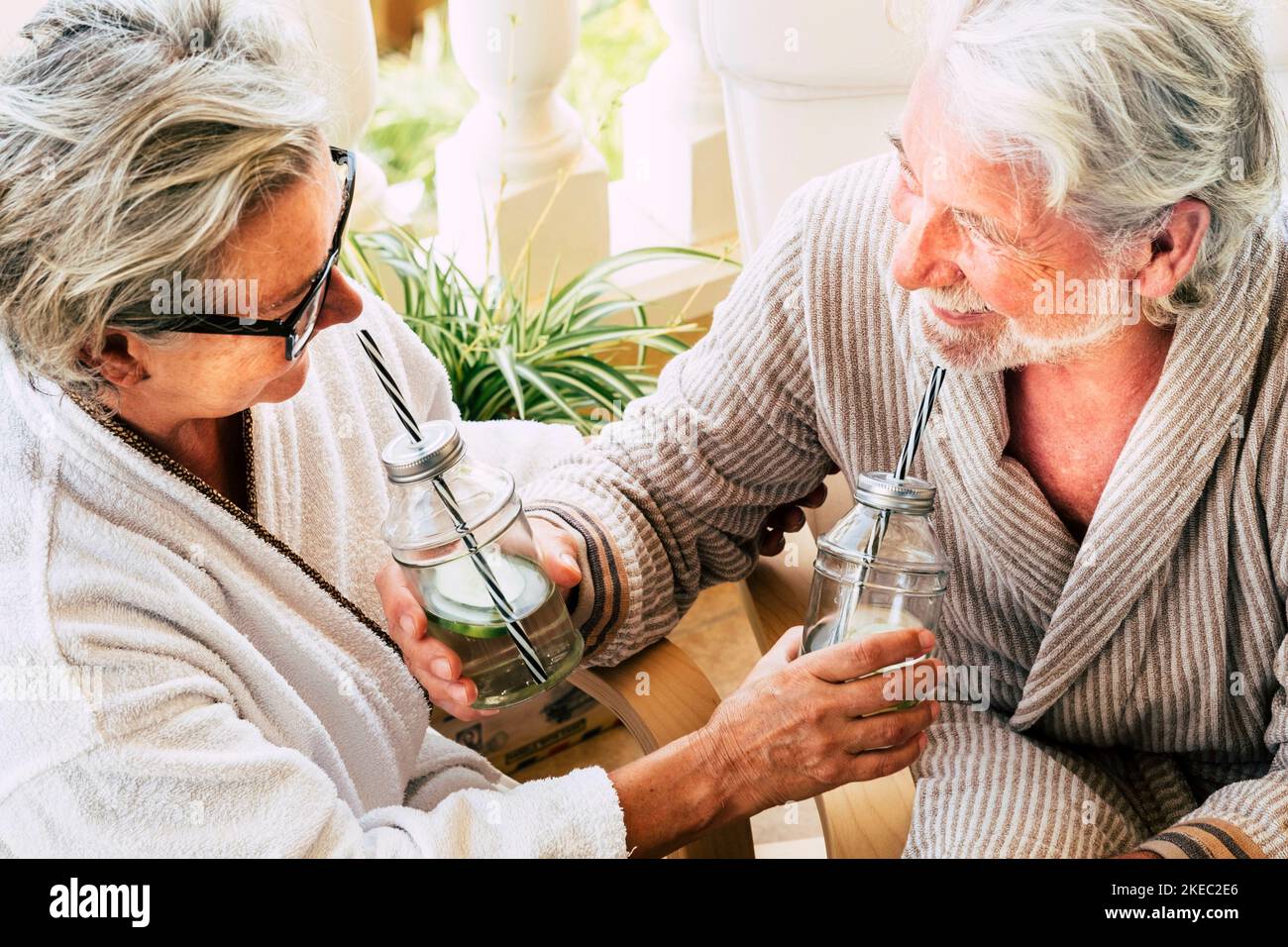 beautiful couple of two mature adults and senior having fun and drinking their cocktail between - resort in a hotel - beauty farm Stock Photo