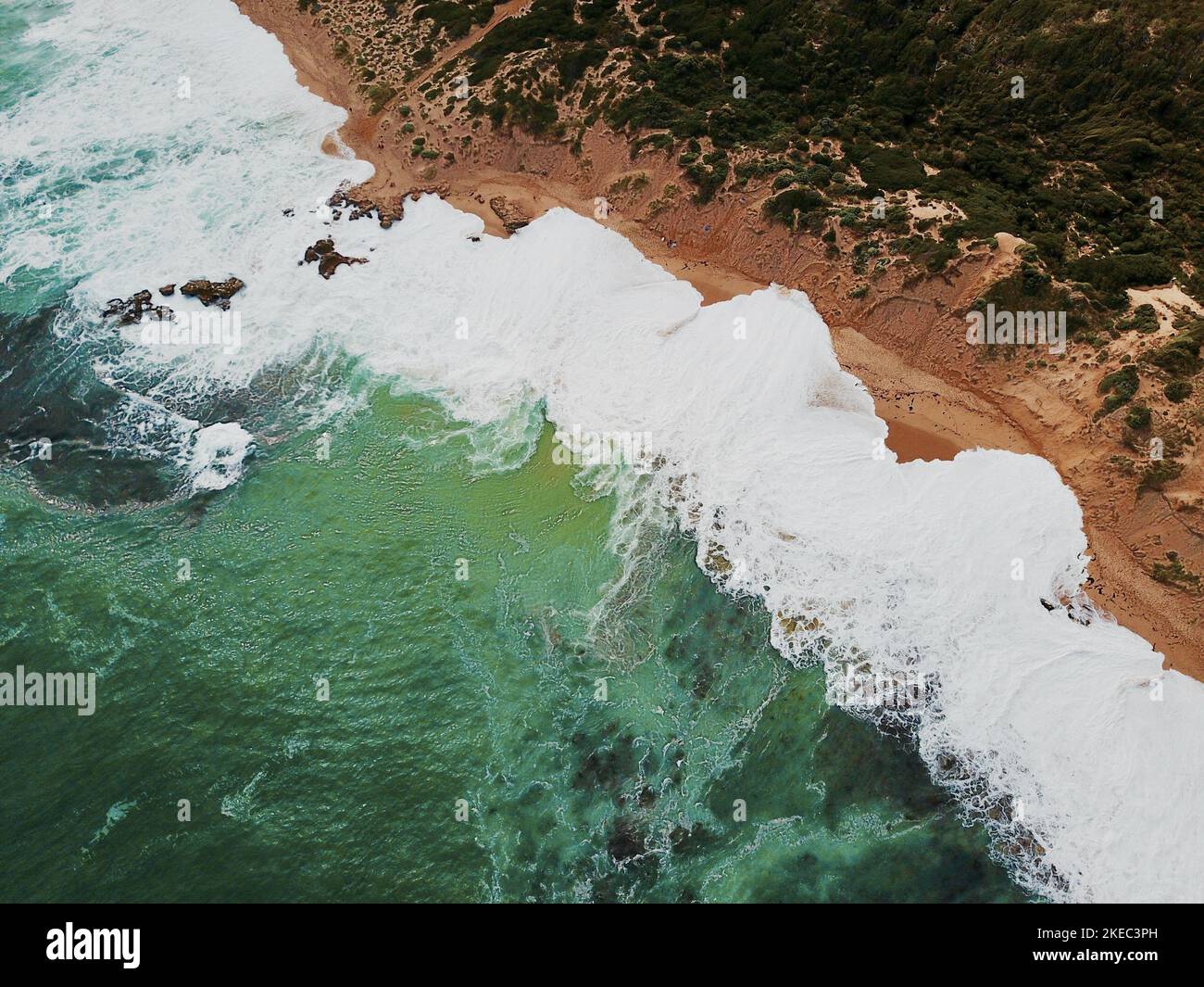 An aerial view of ocean waves with foam on a sandy beach Stock Photo ...