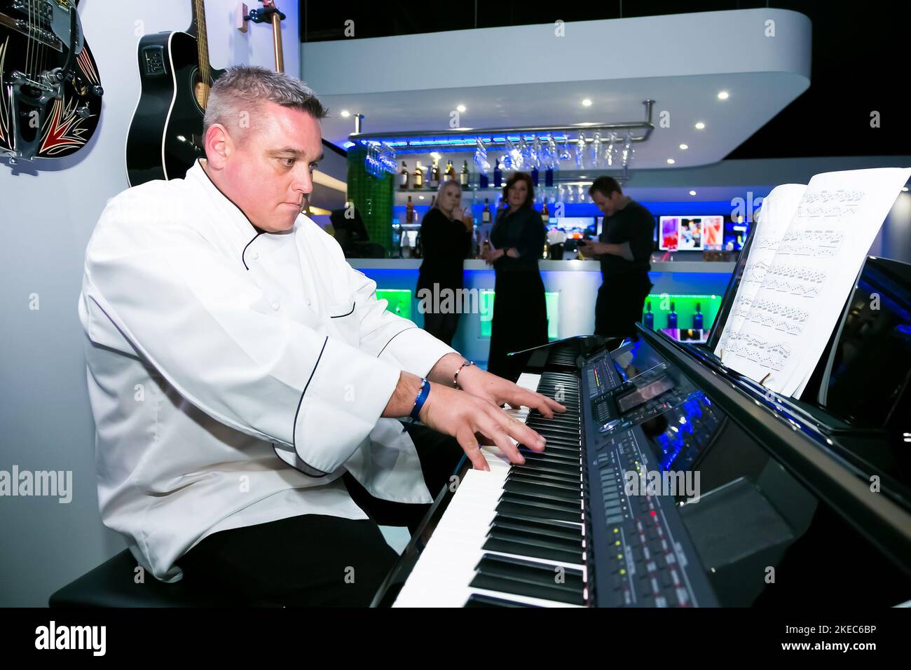 A male musician playing the piano in a busy bar in Johannesburg, South