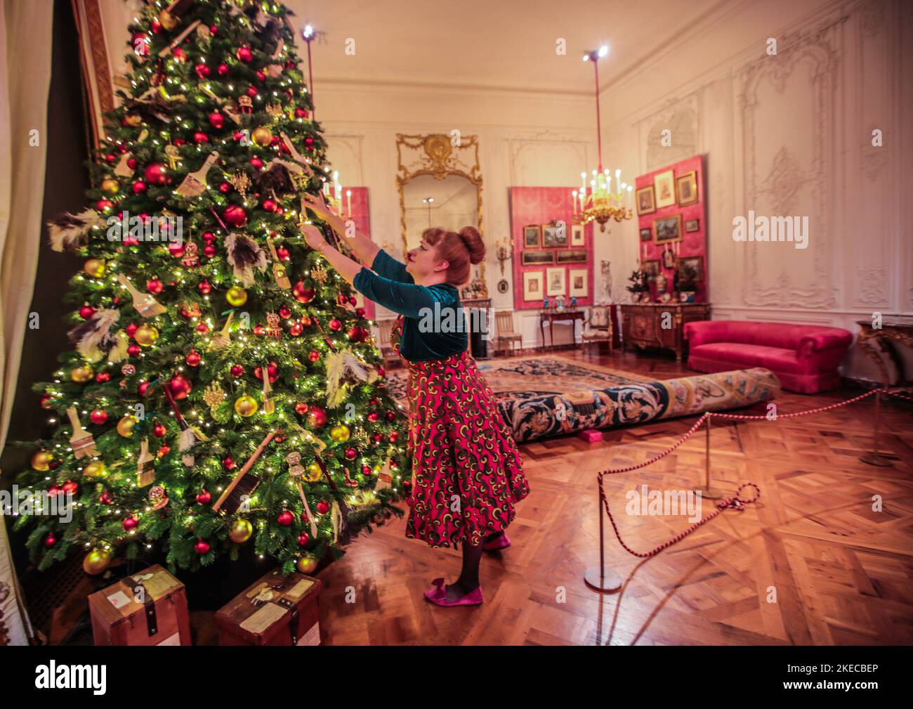 Waddesdon Manor Buckinghamshire, England.11 Nov 2022   Under the watchfull eye of  Gaingsborough  Pink Boy a staff at Waddesdon manor put the finl touches to one of the many Xmas tress inside the house  open for the first time since 2019.From 12 November 2022 – 2 January 2023.Paul Quezada-Neiman/Alamy Live News Stock Photo
