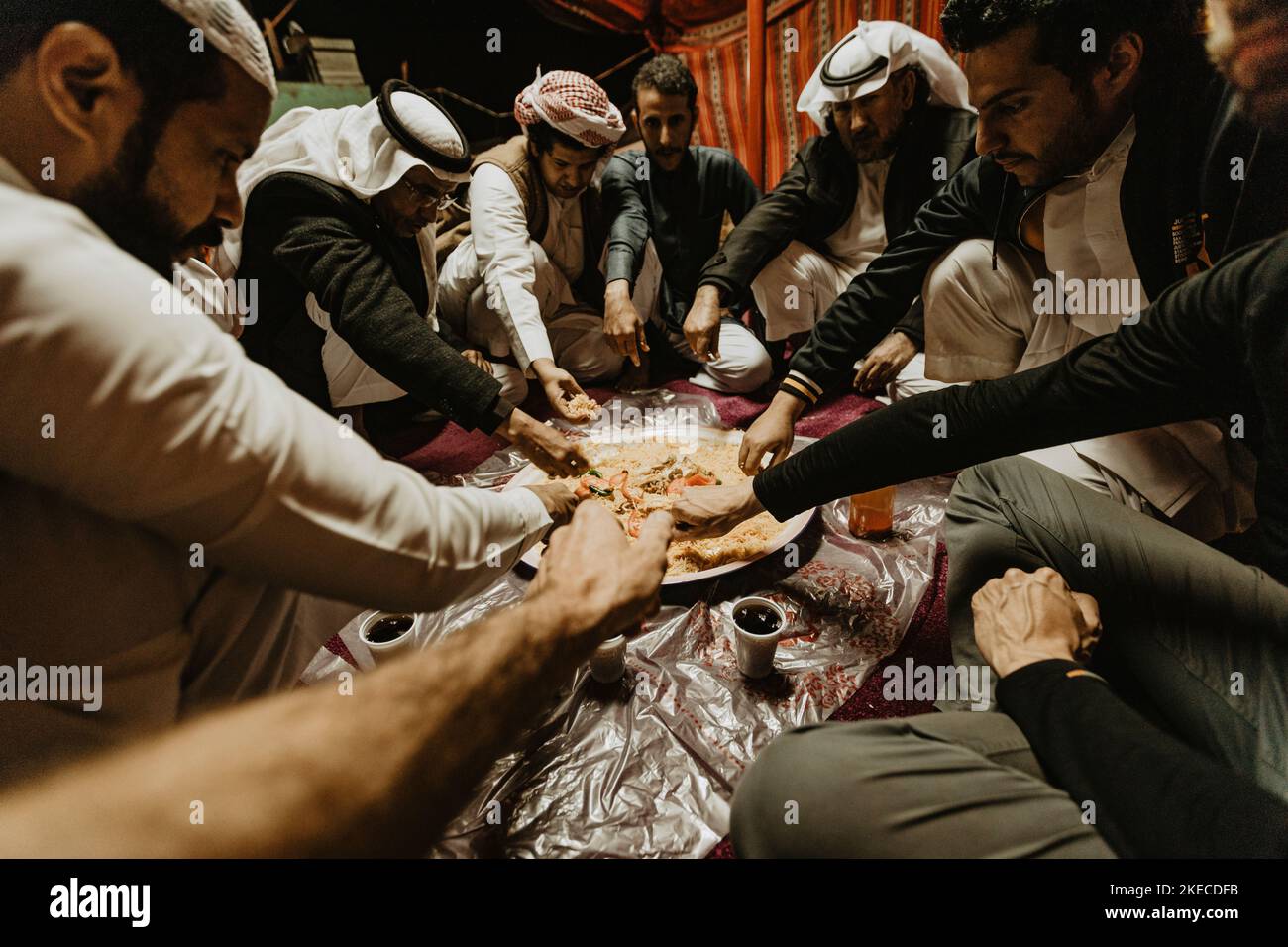 Saudi Arabia, Najran province, Najran, men, sit, eat Stock Photo