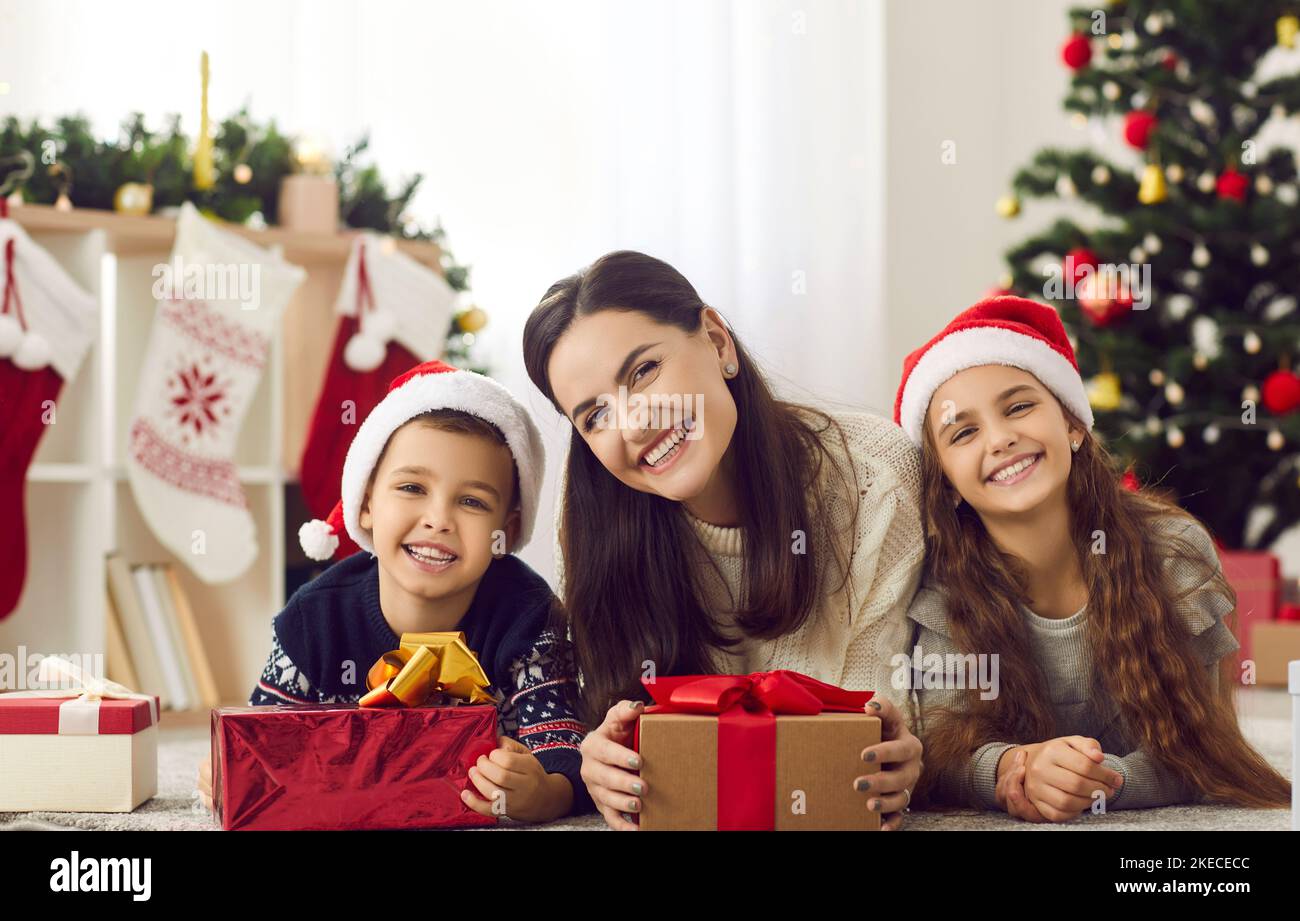 Portrait of happy family - mother, daughter and son enjoying Christmas holidays together. Stock Photo