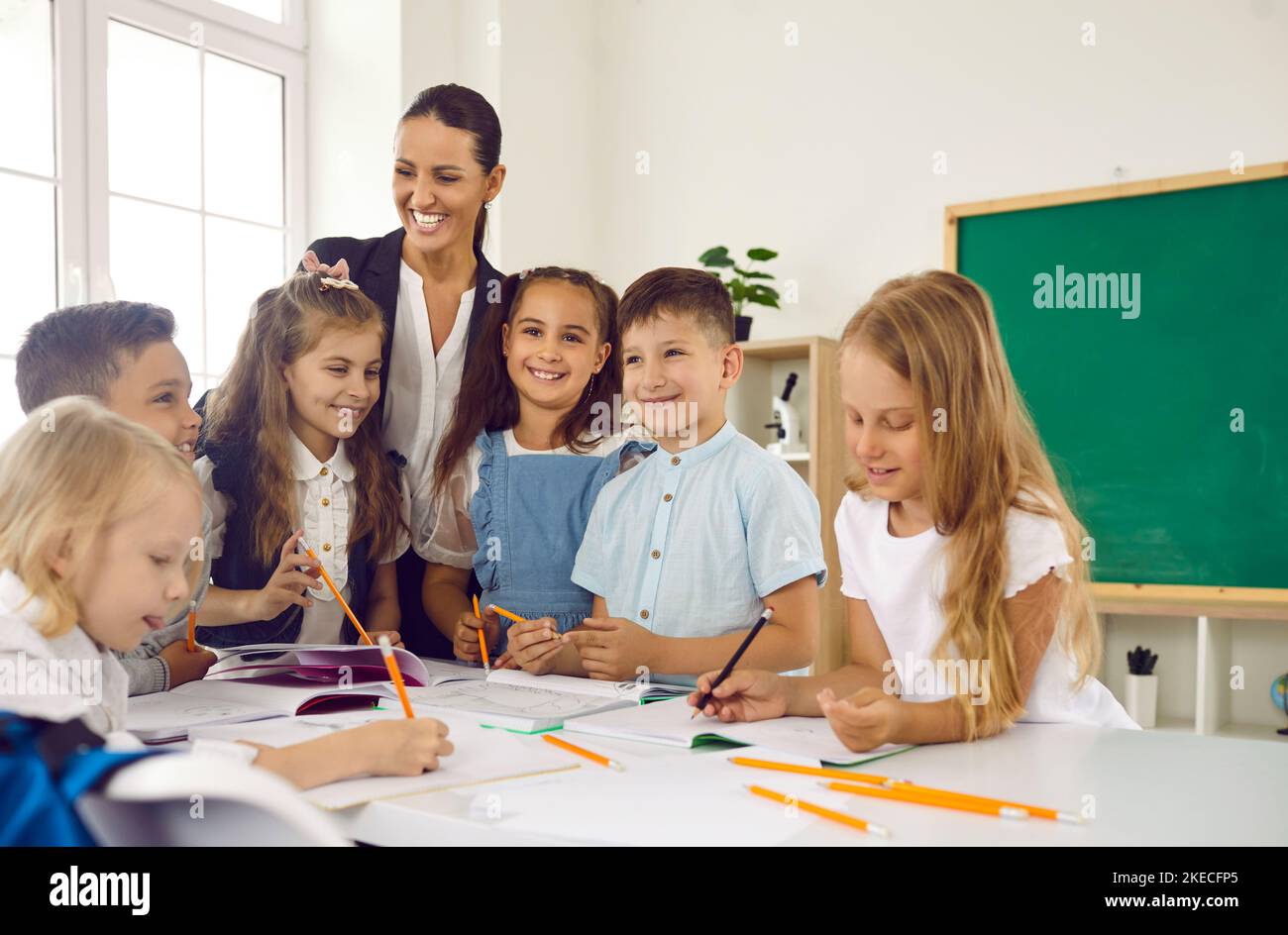 Happy little children learning draw in elementary school stand in