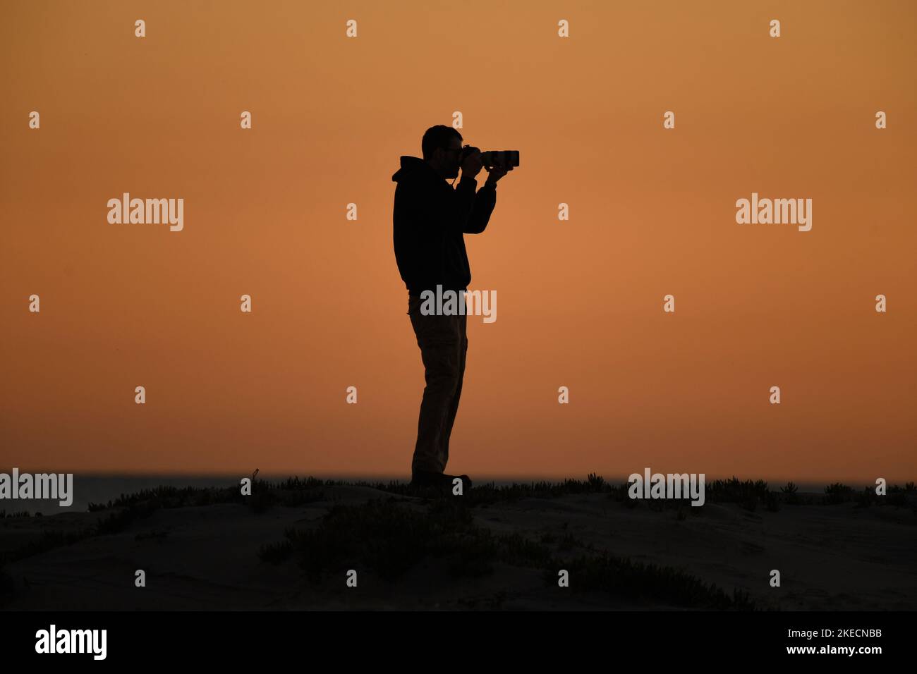 Photographer at work on the beach in Coronado, California at sunset Stock Photo