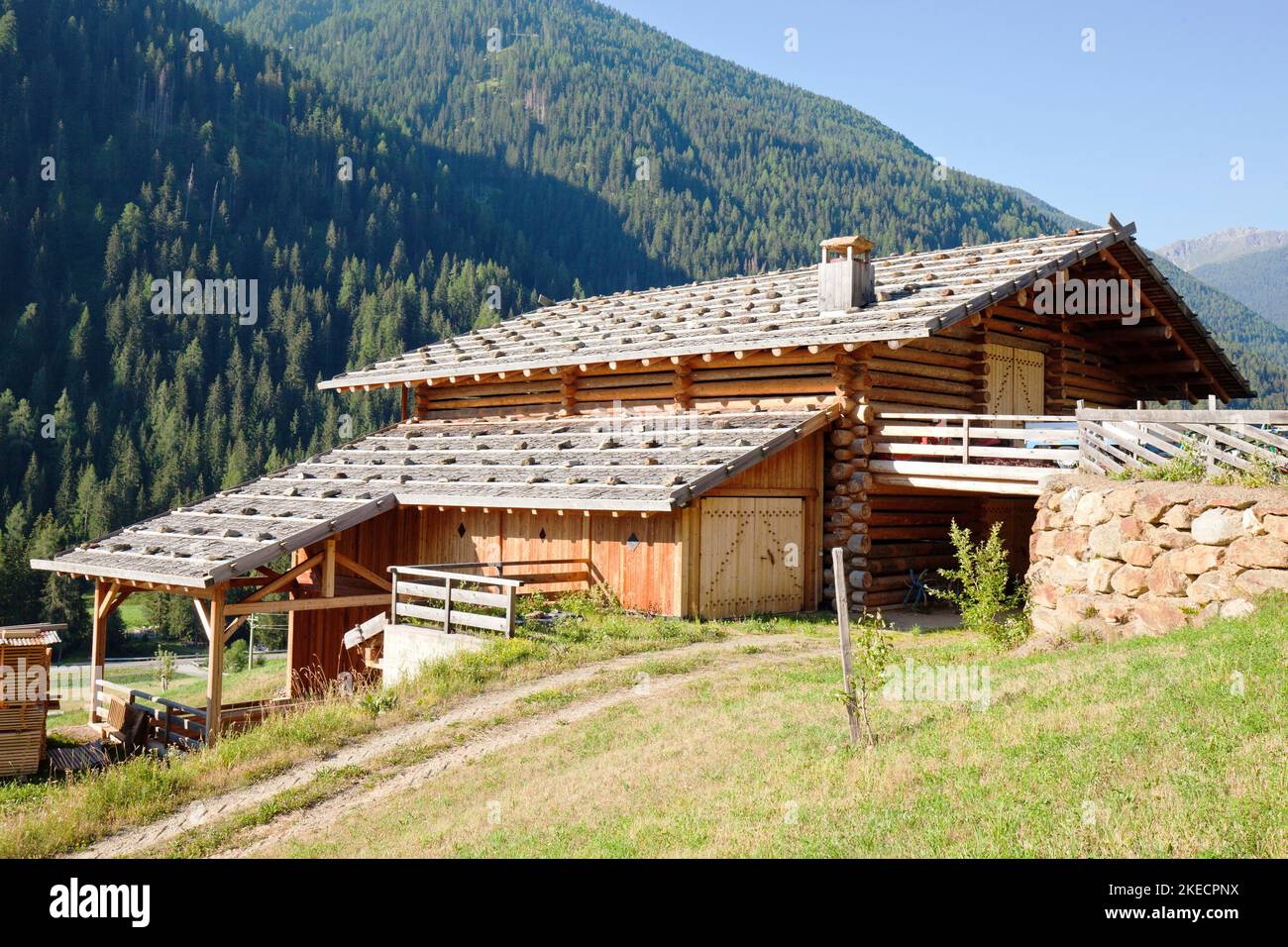 New construction of a mountain farm in typical country style on steep meadow terrain in the South Tyrolean Ulten Valley Stock Photo