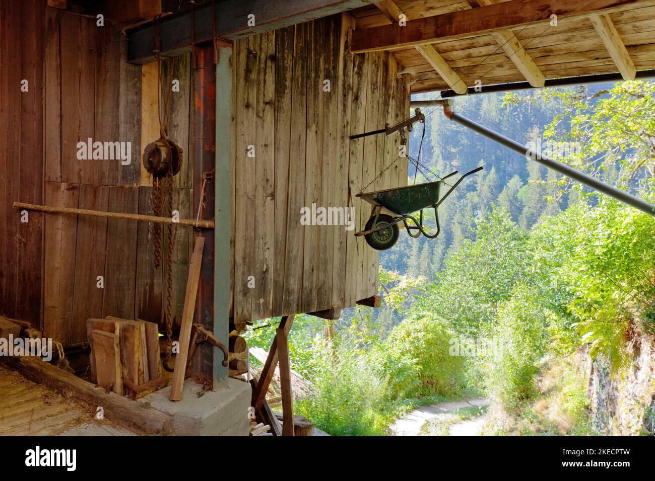 Wheelbarrow hangs secured under the roof of the barn in the South Tyrolean Ulten Valley Stock Photo