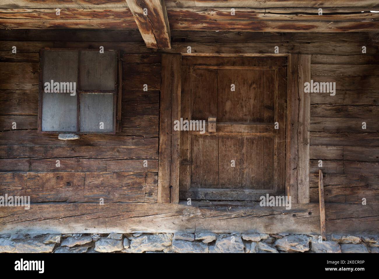 low wooden cellar door at abandoned mountain farm in South Tyrolean Ulten Valley Stock Photo