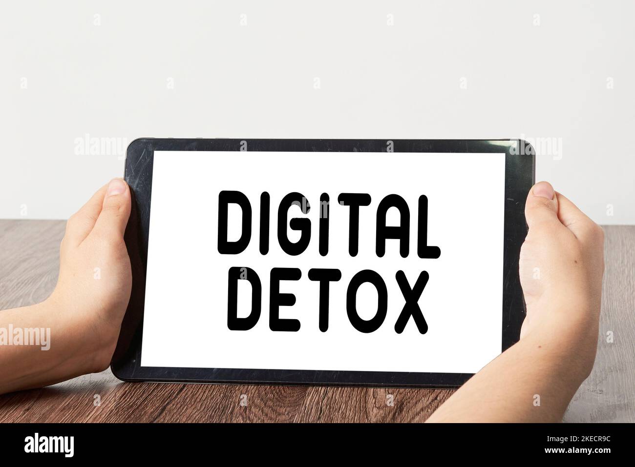 two hands holding a tablet with the word digital detx on it and an image of someone's hand Stock Photo