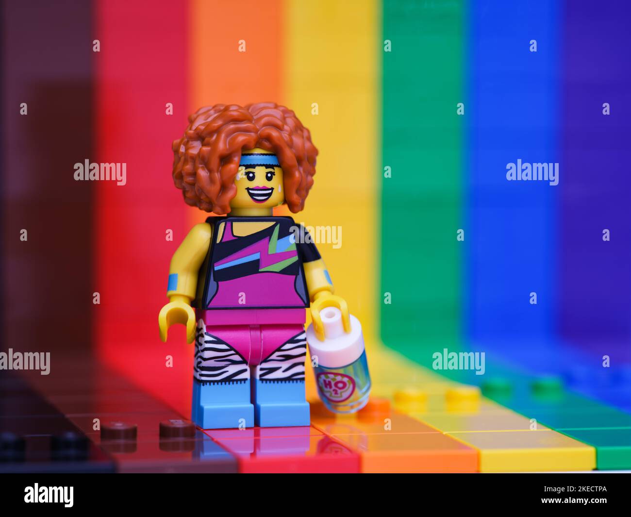 Tambov, Russian Federation - November 07, 2022 A Lego Dance Instructor minifigure with water bottle standing against a rainbow backdrop Stock Photo