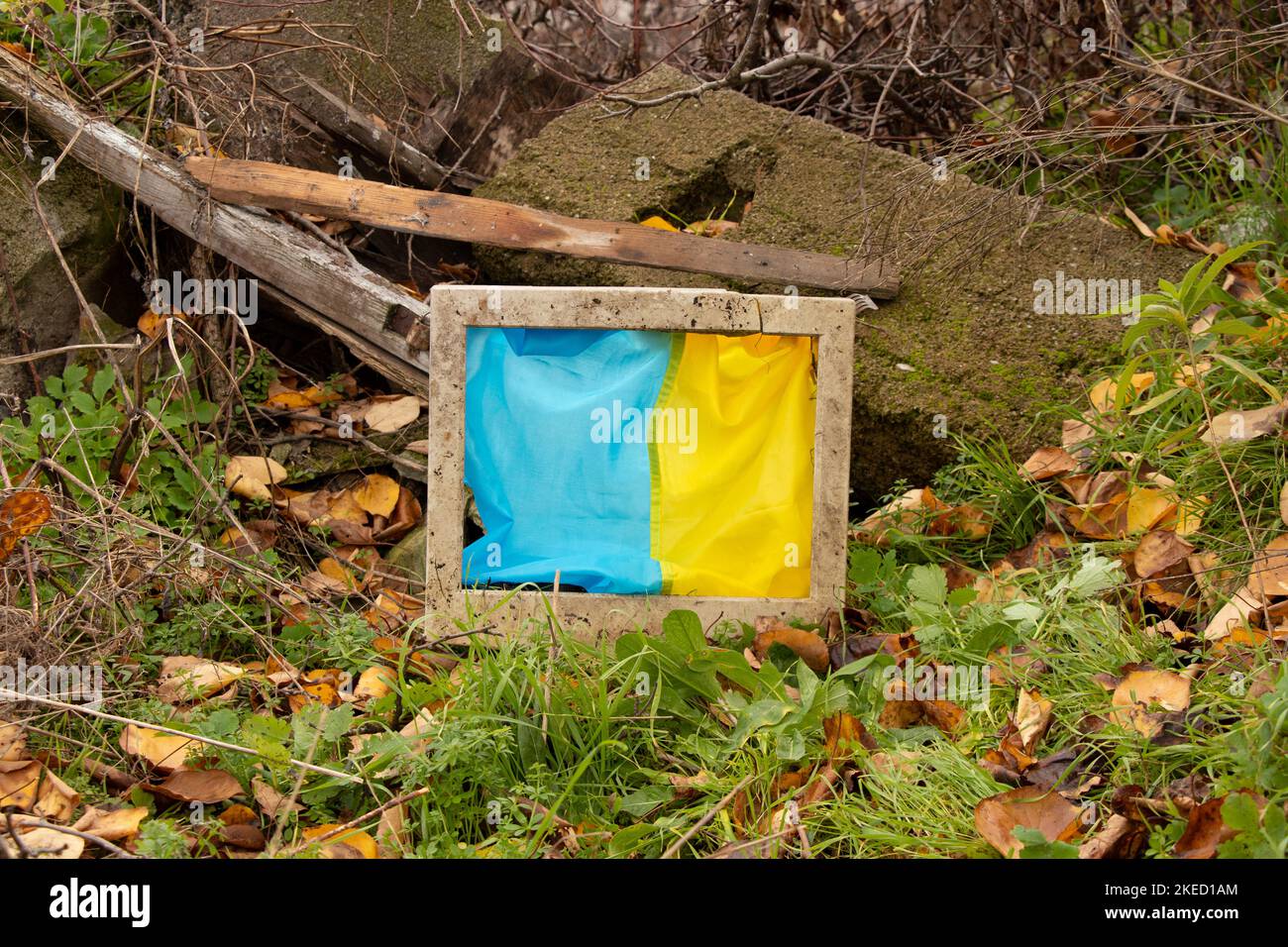 The flag of Ukraine hangs in an old broken computer screen on the ruins ...