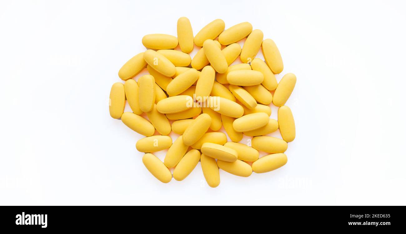 Close-up texture of yellow multivitamin tablets on white background. Healthy lifestyle concept Stock Photo