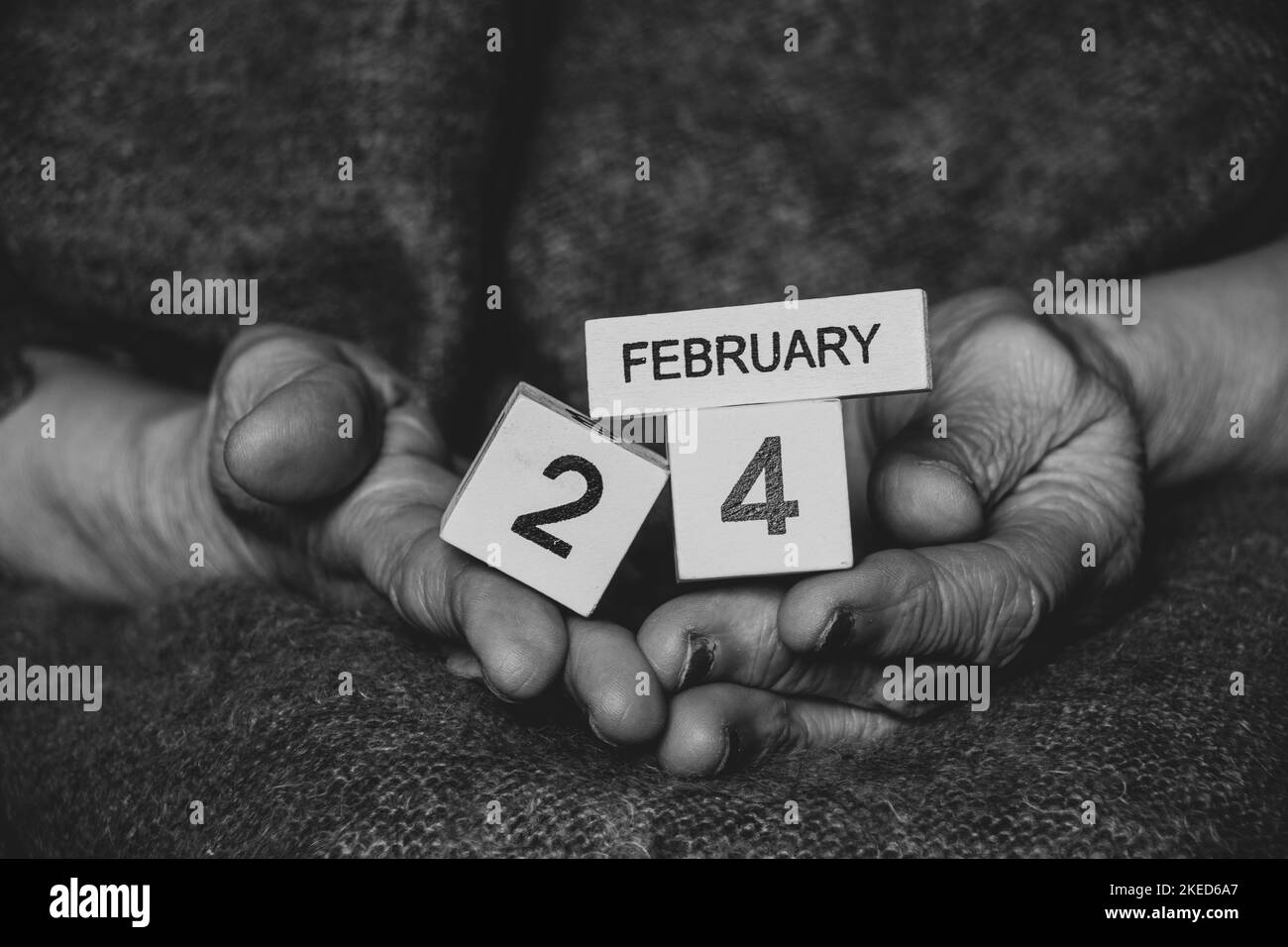 Wooden calendar with the date February 24, the first day of the war in Ukraine in the hands of an old grandmother, historical date, war 2022 Stock Photo