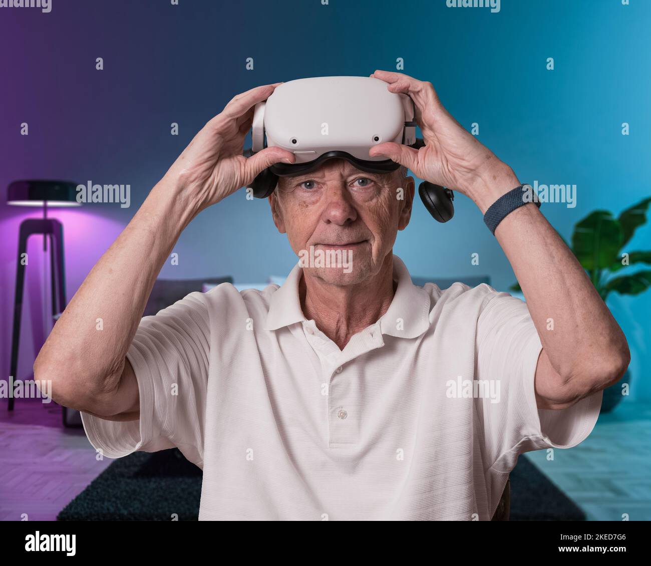 Senior adult man removing his virtual reality headset after exploring a scene in the metaverse Stock Photo