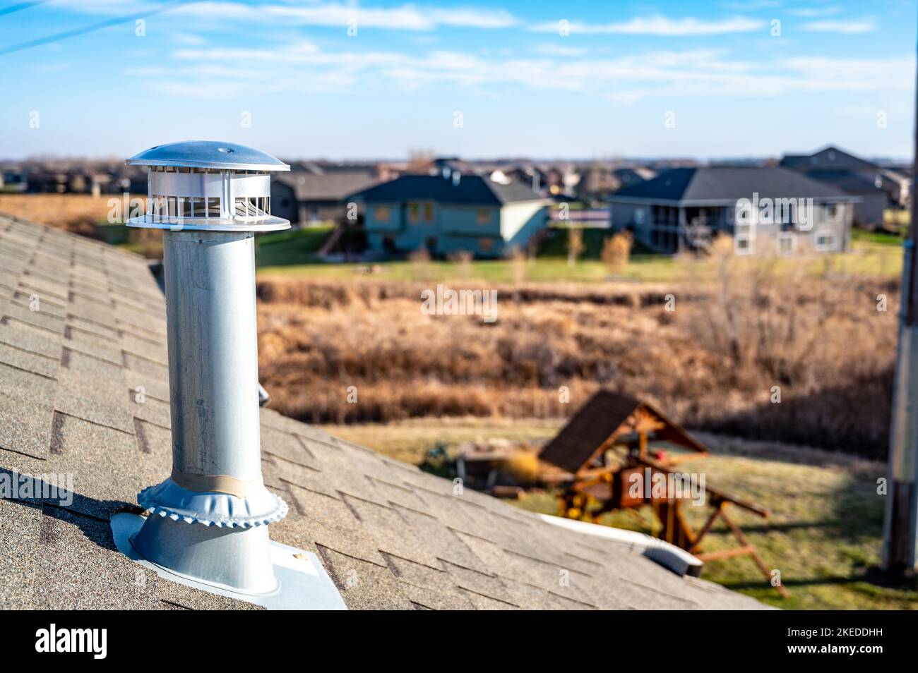 side view of a Galvanized metal chimney exhaust on asphalt roof with a