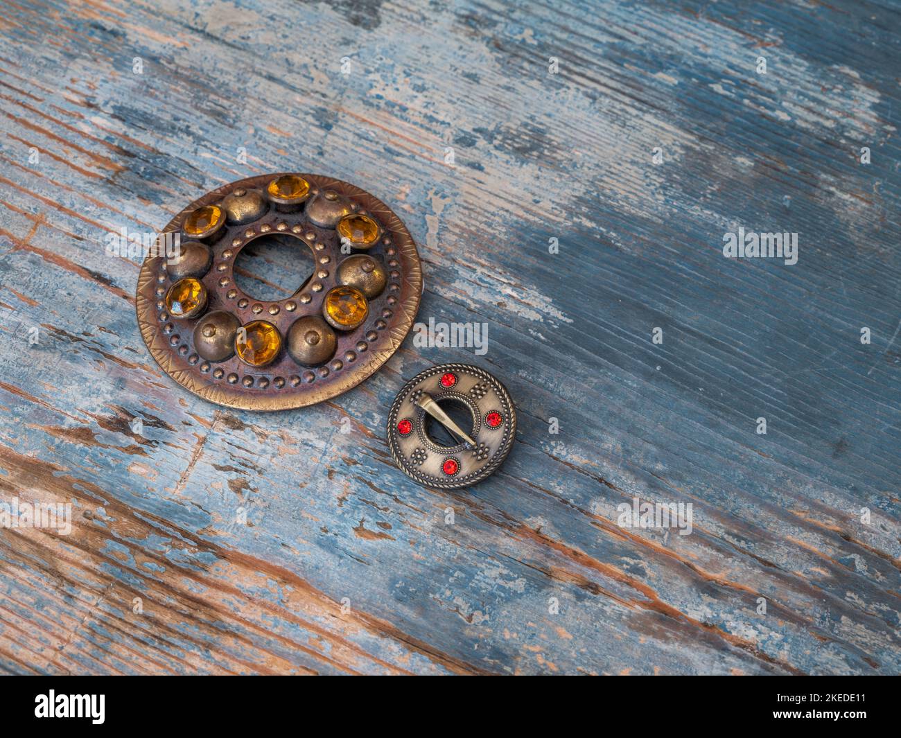 Close-up of two brooches on wood. National decoration of Balts - Sakta Stock Photo