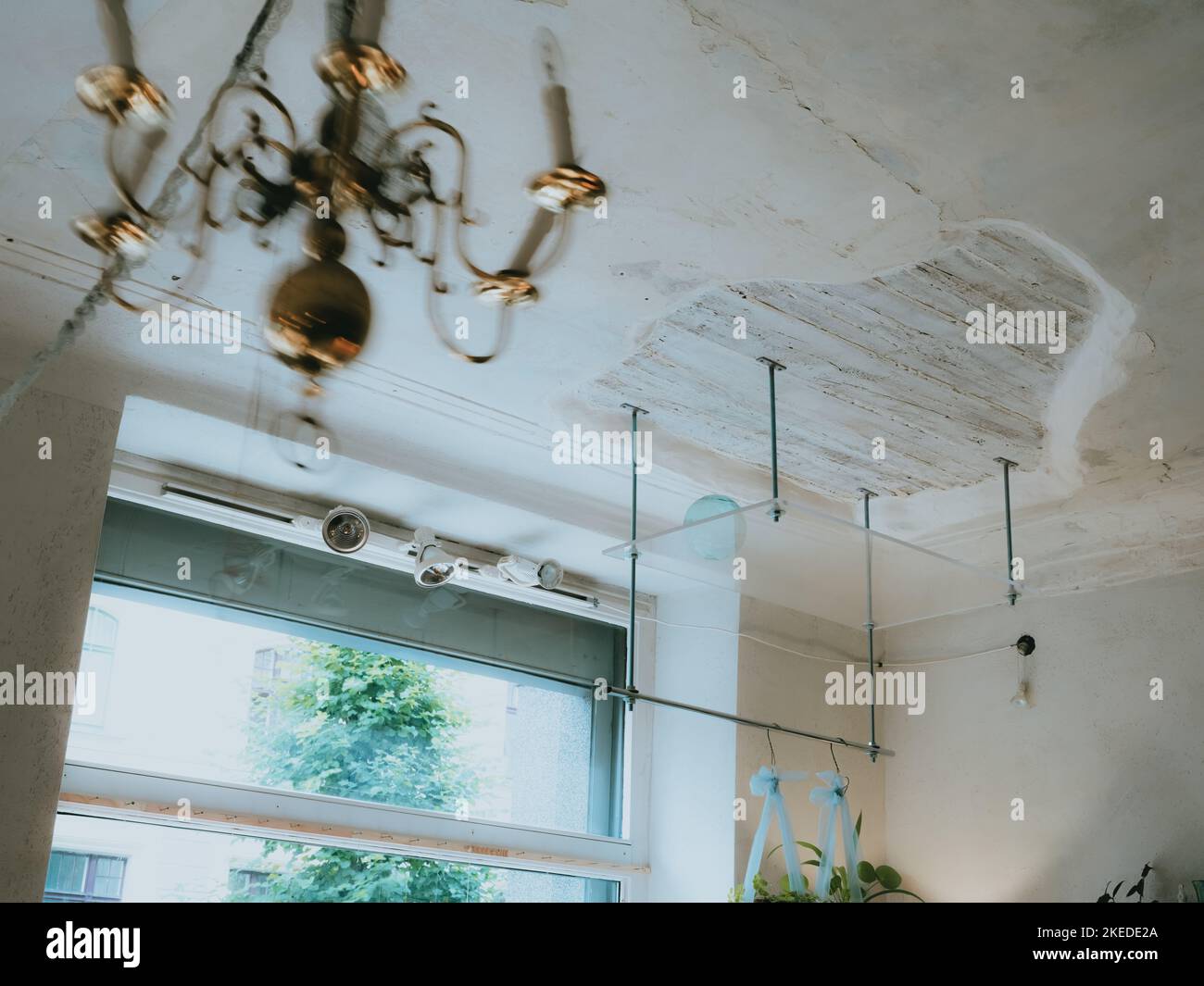 Antique style white ceiling with wooden part. Glass hanging shelf
