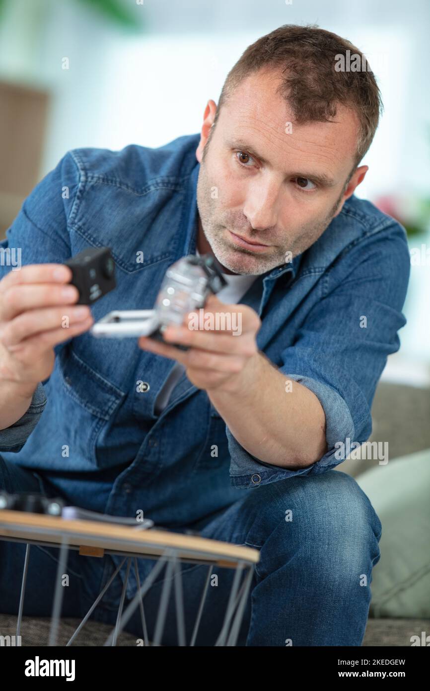 man holds small action camera selective focus Stock Photo