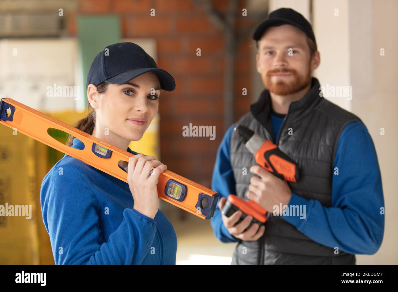 builders with a drill and a spirit level Stock Photo