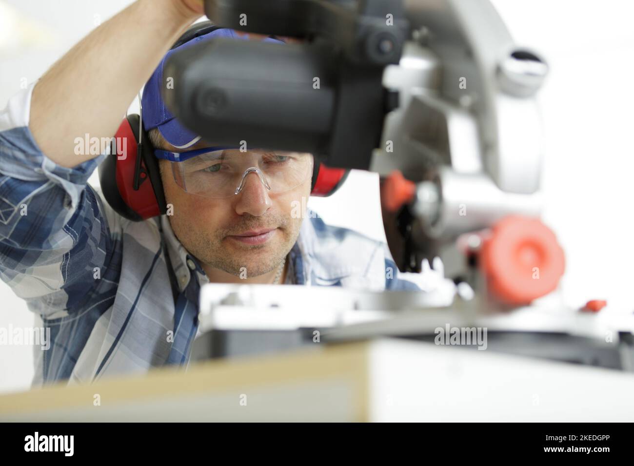 serious worker cutting metal bar with circular saw Stock Photo Alamy