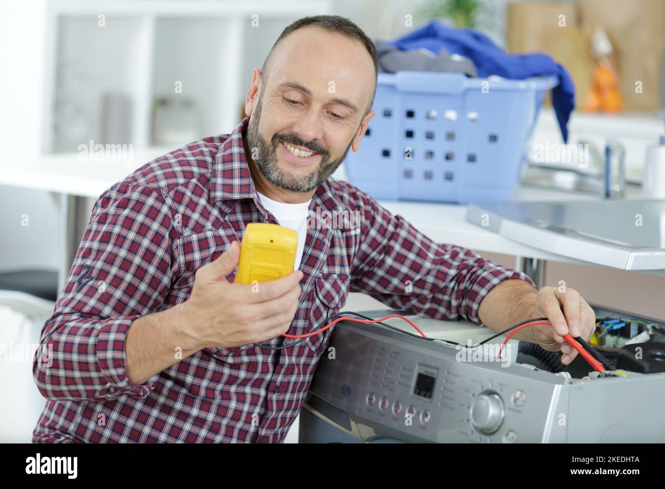 man measures the voltage of washing machine Stock Photo Alamy