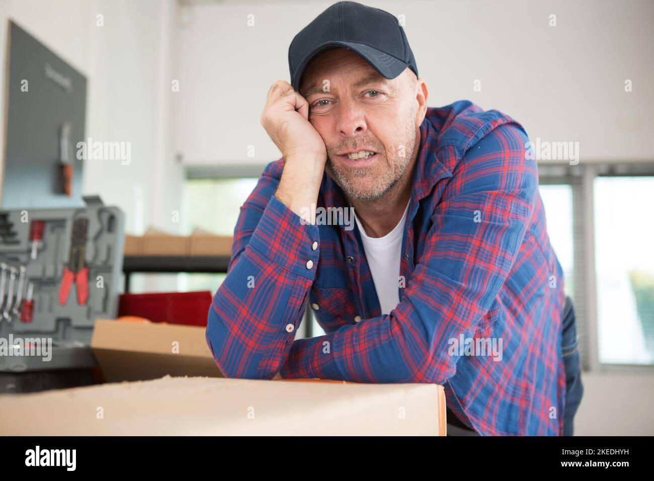 portrair of weary senior handyman with toolkit Stock Photo