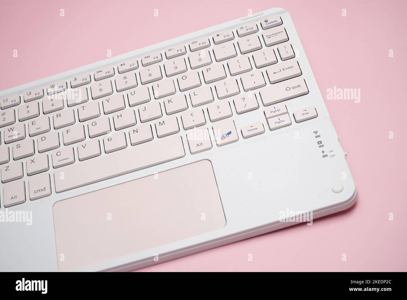working with wireless external portable keyboard isolated pink background Stock Photo