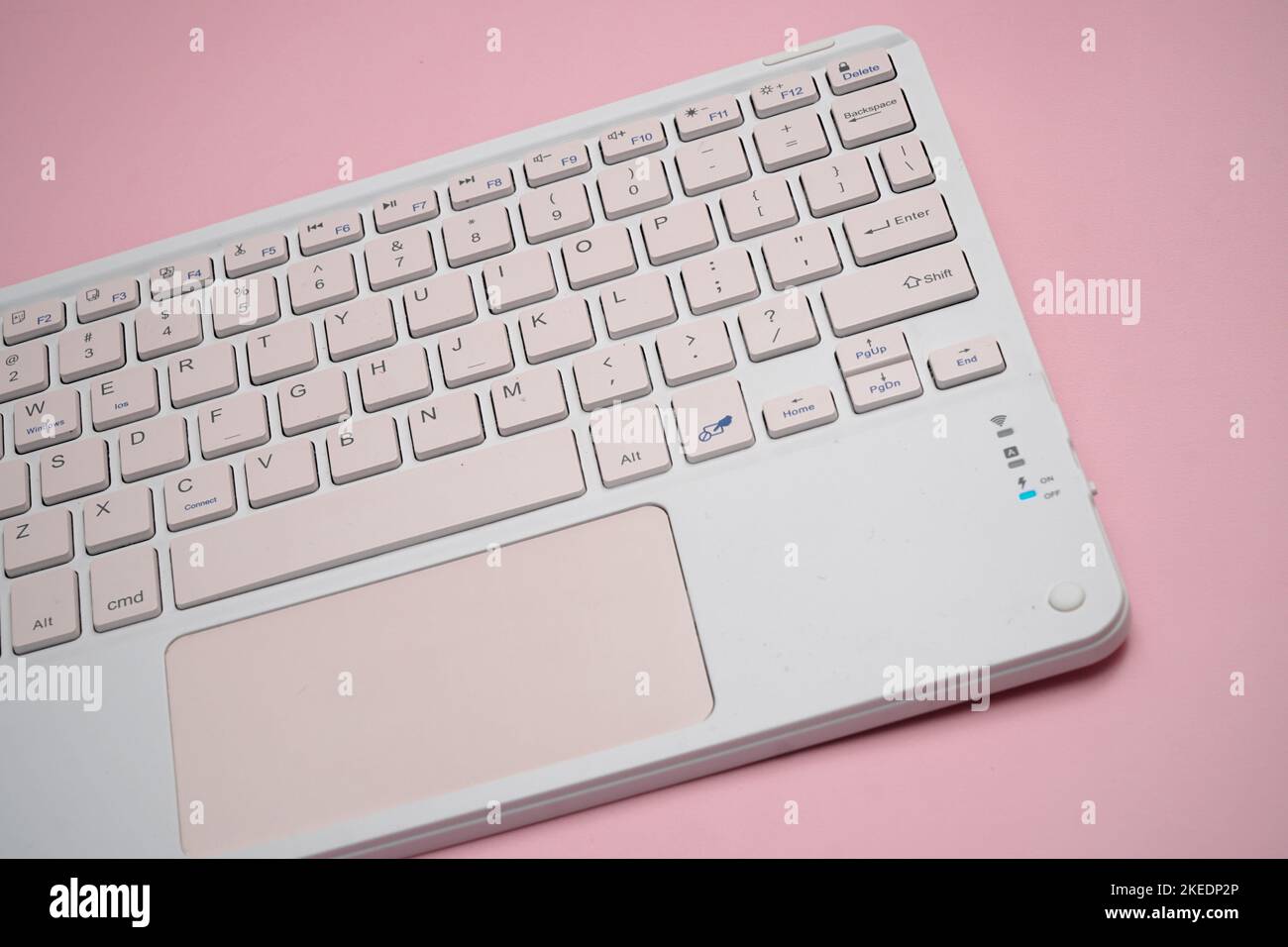 working with wireless external portable keyboard isolated pink background Stock Photo