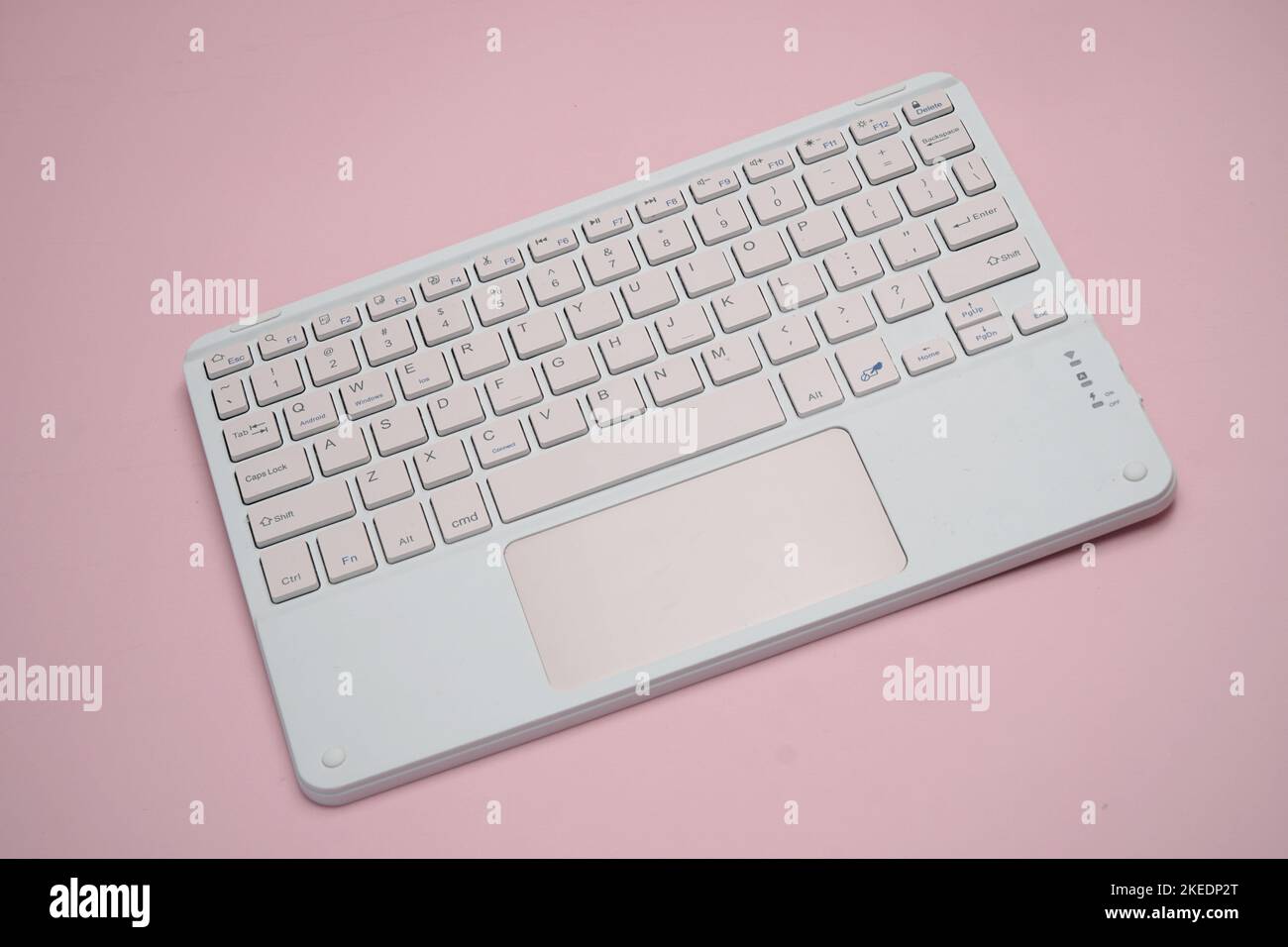 working with wireless external portable keyboard isolated pink background Stock Photo