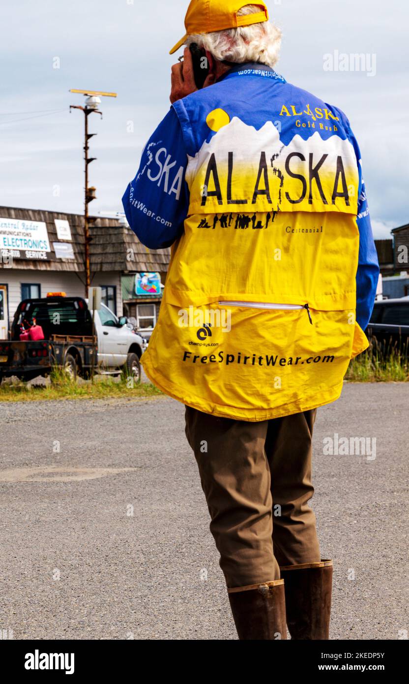 Fisherman on a mobile phone wearing a colorful Alaska jacket; Homer; Alaska; USA Stock Photo