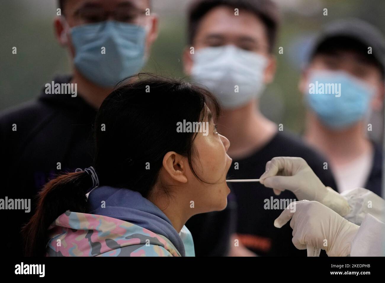 A woman gets tested for the coronavirus disease (COVID-19) at a nucleic acid testing site, following the coronavirus disease (COVID-19) outbreak in Shanghai, China, November 11, 2022. REUTERS/Aly Song Stock Photo
