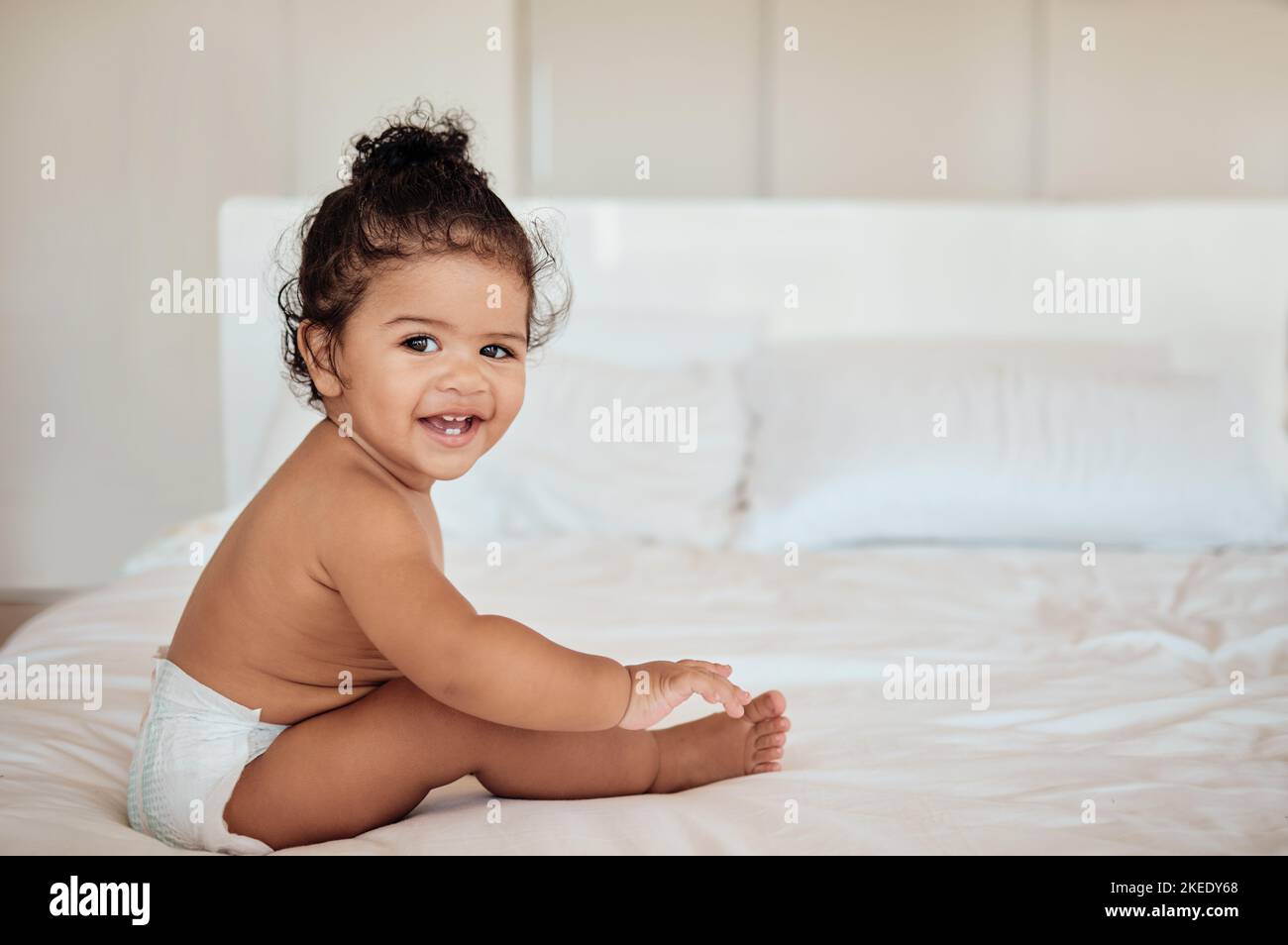 Happy, health and baby on bed portrait in diaper with wellness, cheerful and cute smile in home. Relax, happiness and healthy toddler in disposable Stock Photo