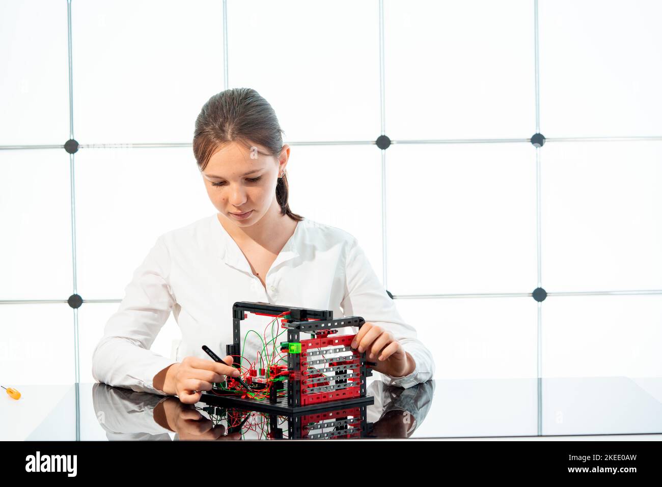 girl student experimenting with an optical electronic setup to study