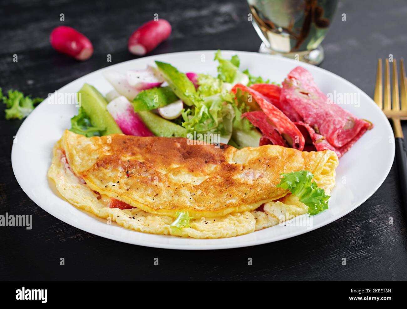 Breakfast. Omelette with cheese and  fresh salad, salami. Frittata - italian omelet. Ketogenic lunch. Stock Photo