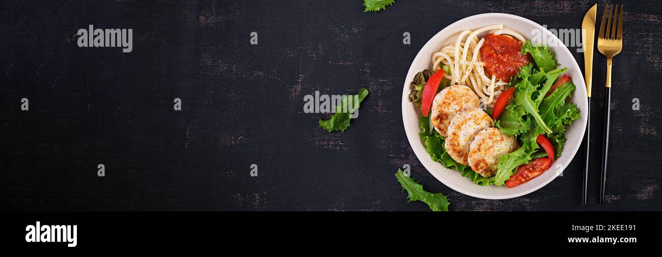 Spaghetti pasta, chicken burgers and salad in bowl. Chicken patties