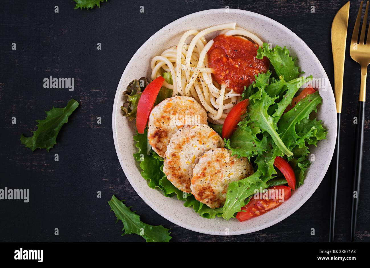Spaghetti pasta, chicken burgers and salad in bowl. Chicken patties