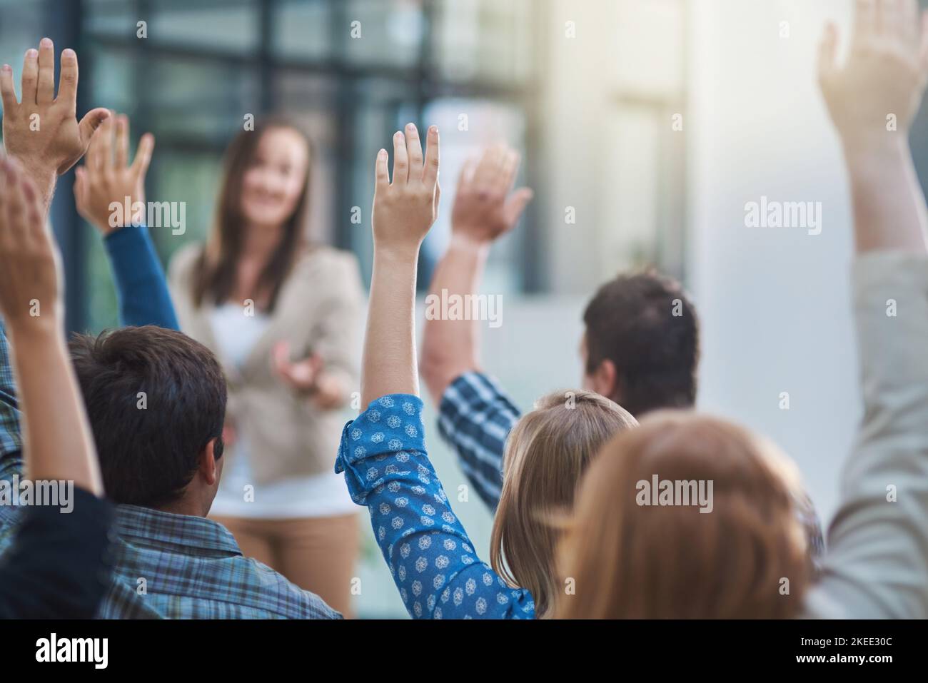 in the office. a group of people raising their hands in a
